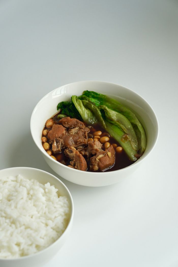 Home Delicious Asian braised pork with bok choy served with white rice, showcasing authentic flavors.